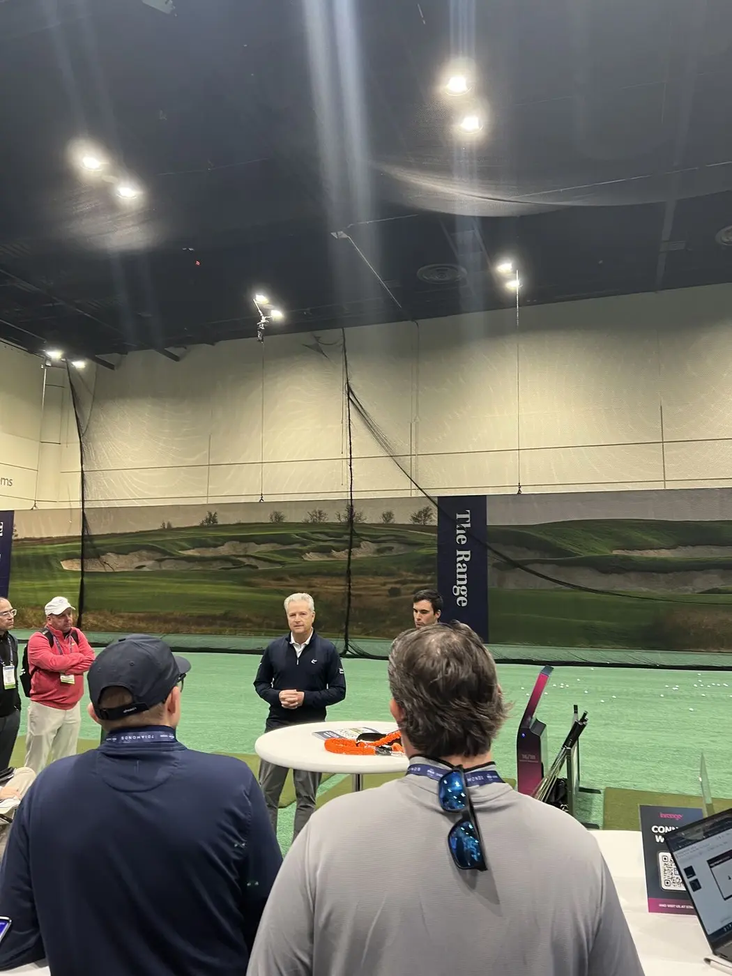 Golf professionals learning together at an indoor range