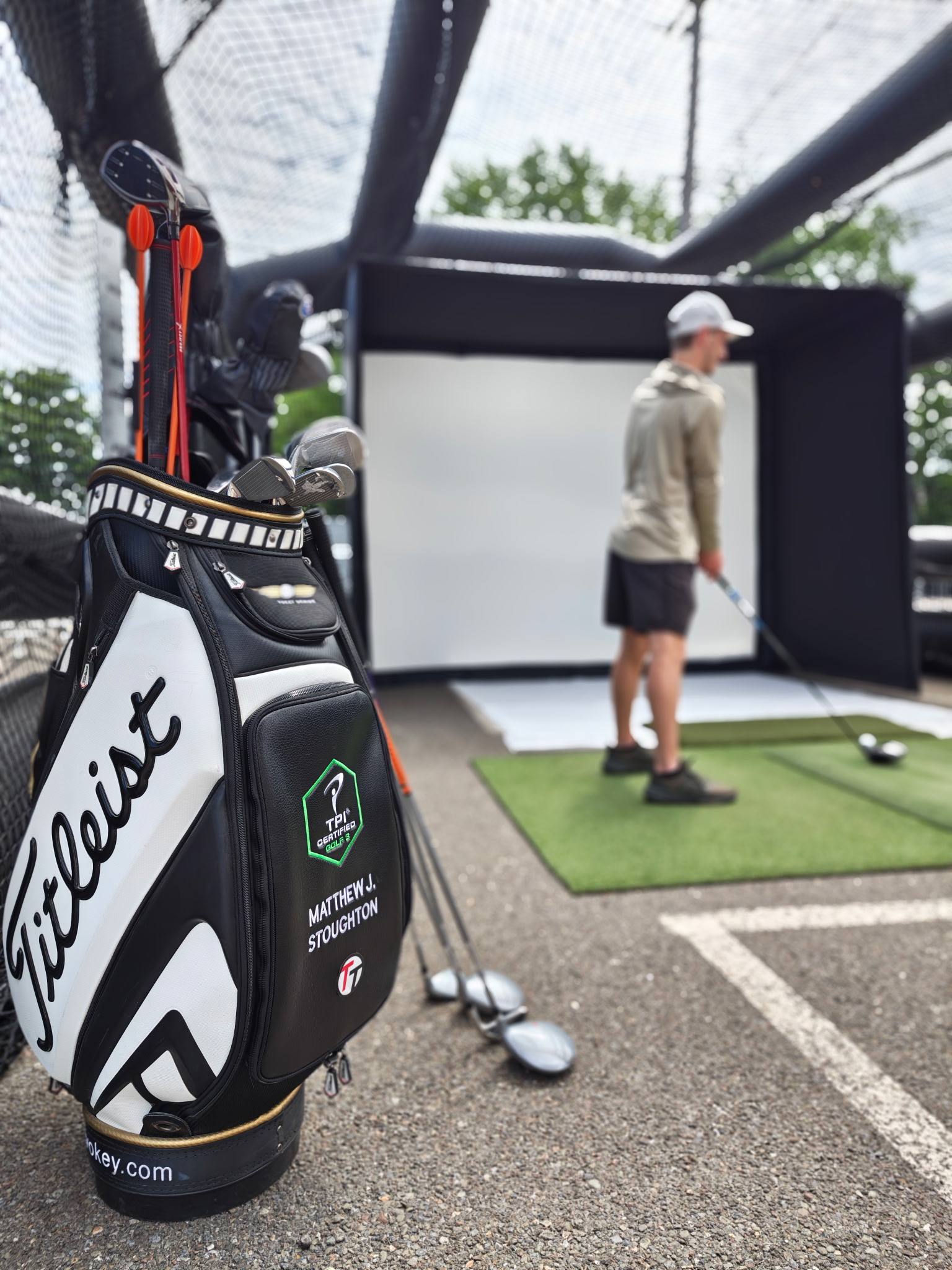 Matt Stoughton's Titleist golf bag beside an outdoor practice bay